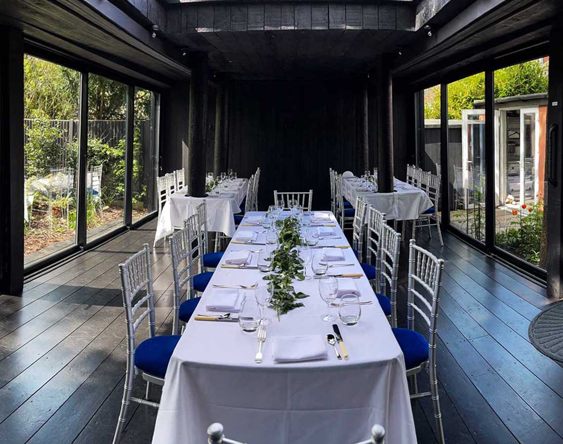 The pavilion with one set table in the middle and 2 smaller tables to the sides and further back